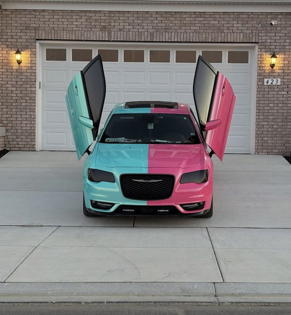 Chrysler 300 wrapped in a split teal and pink color change, doors open